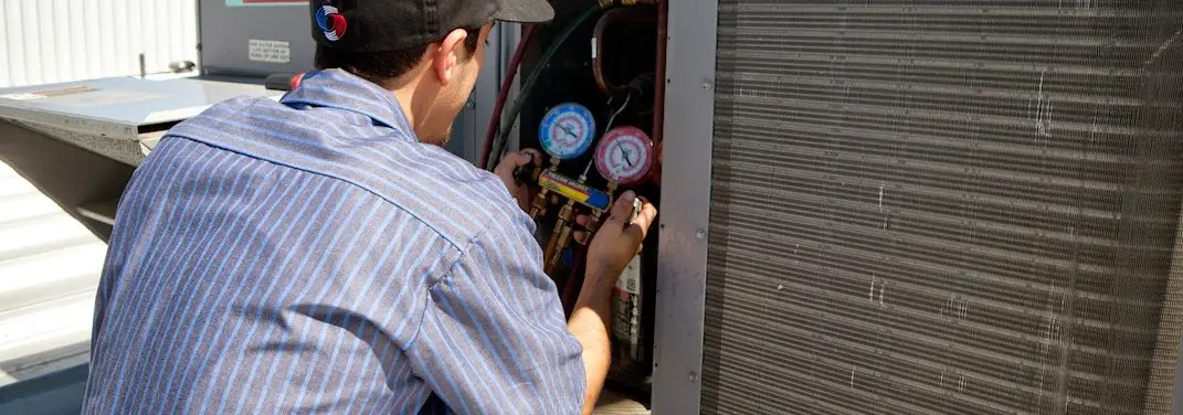 HVAC technician servicing a condenser unit in Wildwood